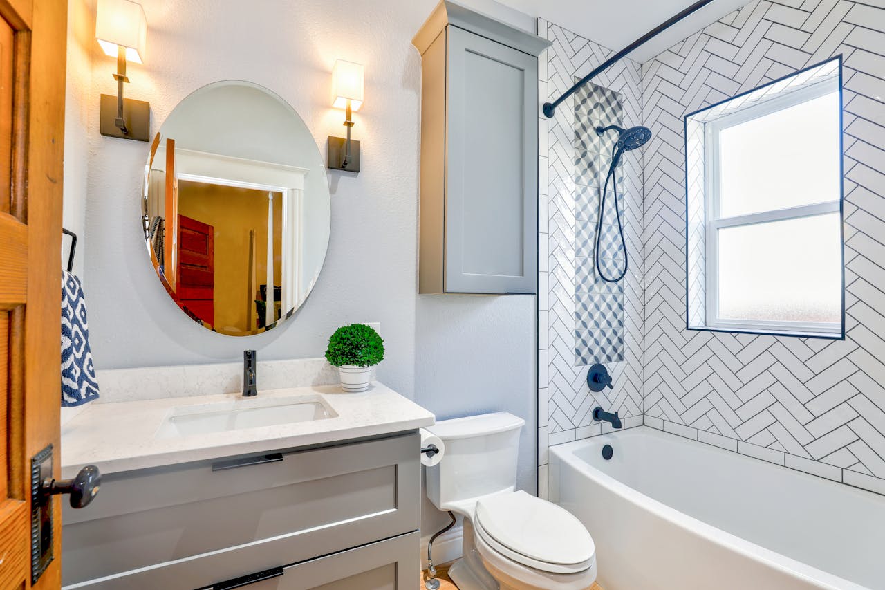 The Art of Drawing Readers In: Your attractive post title goes here Elegant modern bathroom featuring chevron tiles, oval mirror, and sleek fixtures for a contemporary look.